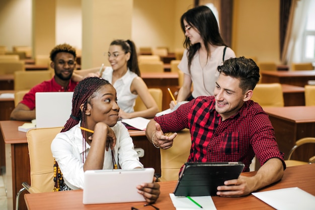 Foto gratuita ragazza nera parlando con il compagno di classe nella biblioteca