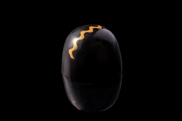 Черно-золотые роскошные шоколадные конфеты ручной работы на черном фоне. Эксклюзивные конфеты ручной работы. Концепция продукта для шоколатье