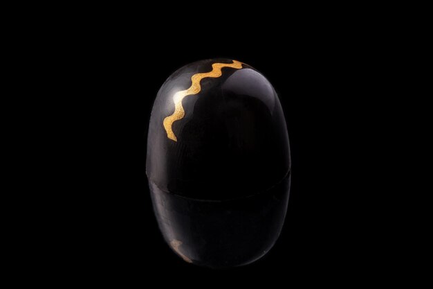 Black and gold colored luxury handmade chocolate candy on black background. Exclusive handcrafted bonbon. Product concept for chocolatier