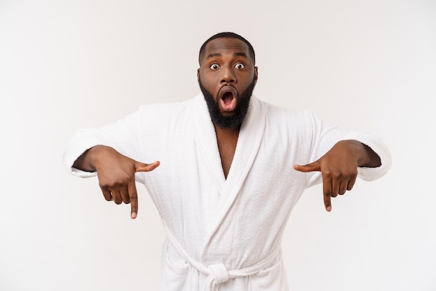 Black guy wearing a bathrobe pointing finger with surprise and happy emotion Isolated over whtie background