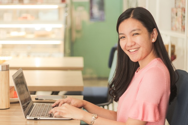 Free photo black-haired lady sitting in front of her laptop in the office