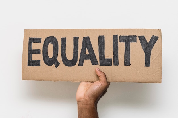 Free Photo black hand holding equality on cardboard