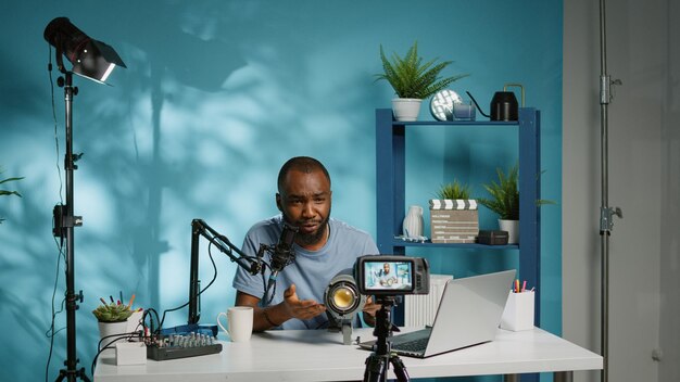카메라에 대한 vlog 검토를 위해 스튜디오 조명에 대해 이야기하는 흑인 인플루언서. 비디오 촬영 장비를 위한 전문 도구를 검토하고 추천을 위해 장비를 들고 있는 아프리카계 미국인 블로거