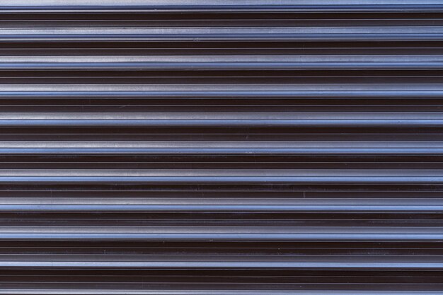 Black iron tin fence lined background. Metal texture