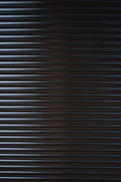 Black iron tin fence lined background. Metal texture