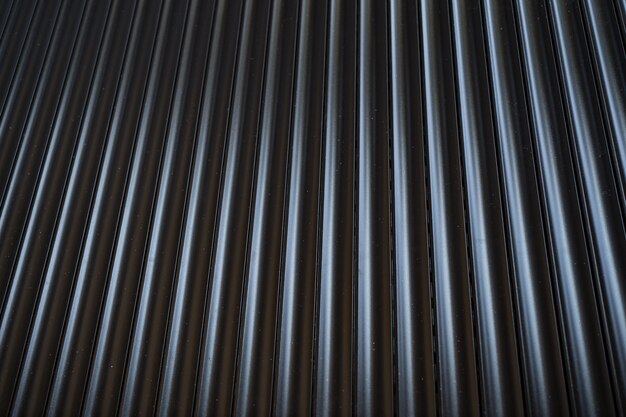 Black iron tin fence lined background. Metal texture