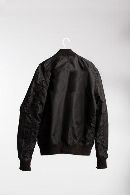 Black jacket on cloth hanger with white wall