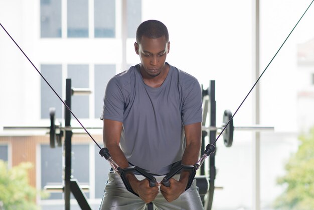 Black man exercising pecs on gym equipment