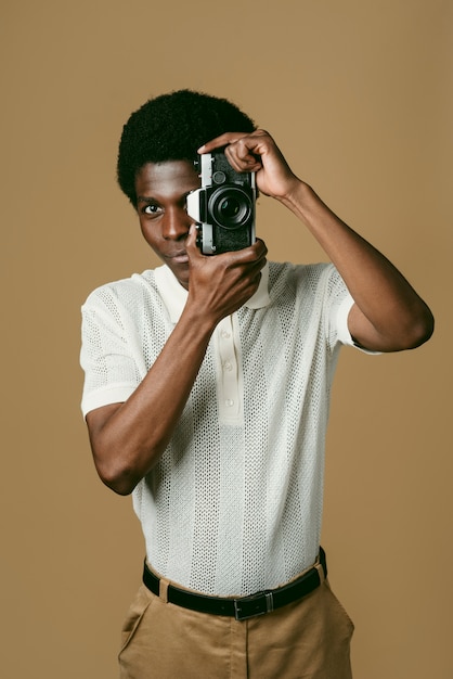 Free photo black man holding photo camera medium shot