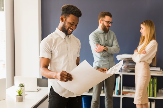 Black man looking at draft in office