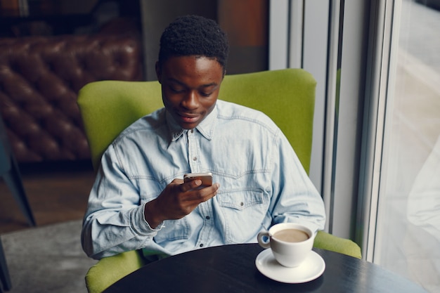 カフェに座ってコーヒーを飲む黒人男性