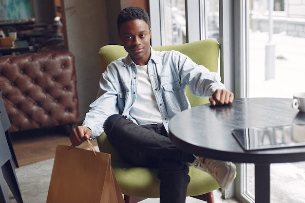 Black man sitting in a cafe and drinking a coffee