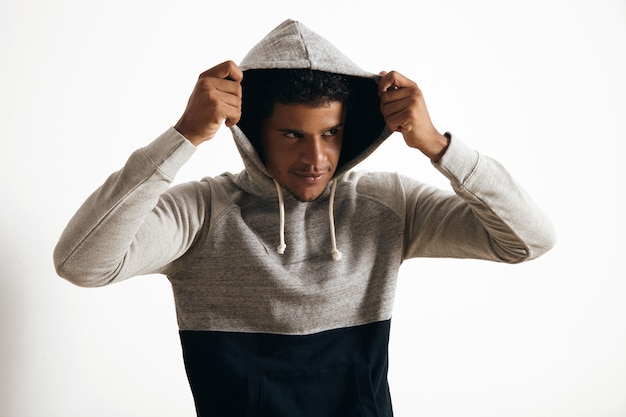 Free photo black man wears hoodie on his head with curly hair , looking miraculously on side, isolated on white