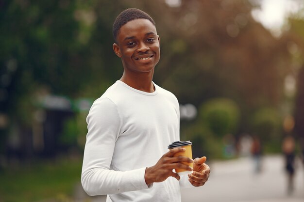 Black man in a white sweater in a summer city