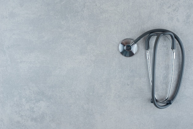 Black medical stethoscope on gray background. High quality photo