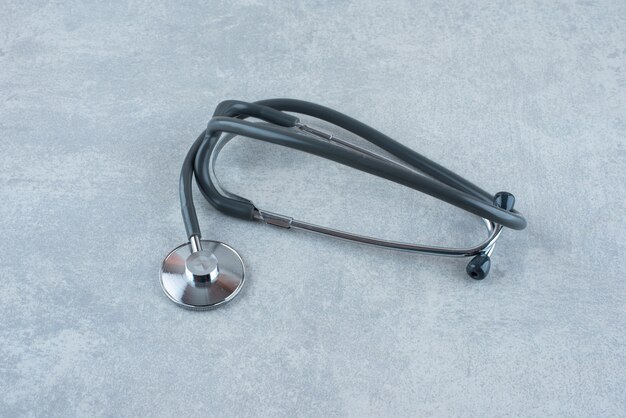 Black medical stethoscope on gray background. High quality photo