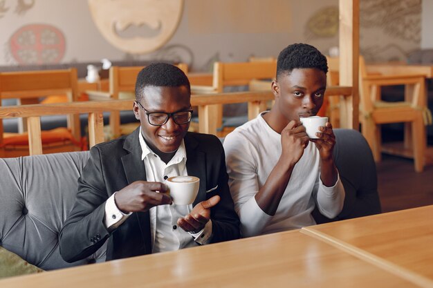 Uomini di colore che si siedono in un caffè e che bevono un caffè