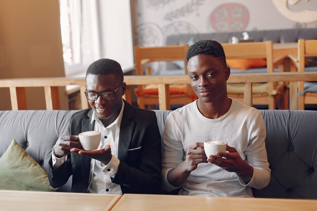 Black men sitting in a cafe and drinking a coffee