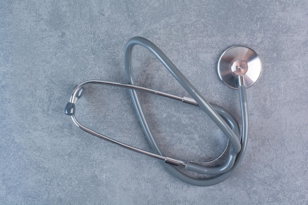 Black metal stethoscope on marble surface