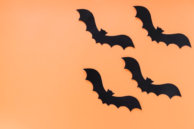 Black paper bats on orange background 