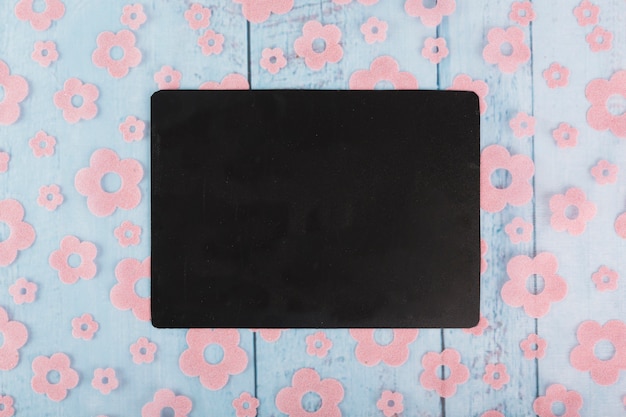 Free photo black paper sheet on floral ornament