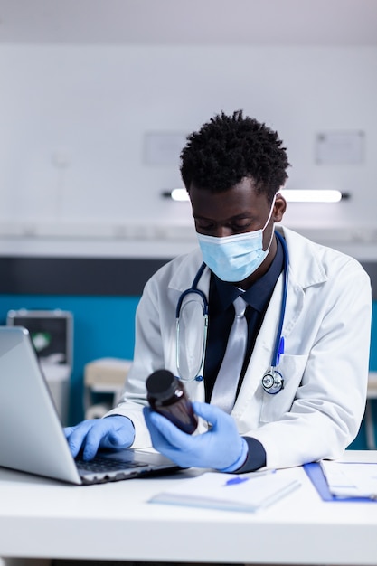 Black person with medic profession using laptop