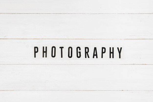 Black photography text on white wooden table