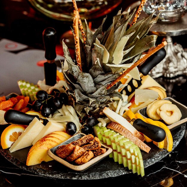 Black plate of fruits and dried fruits