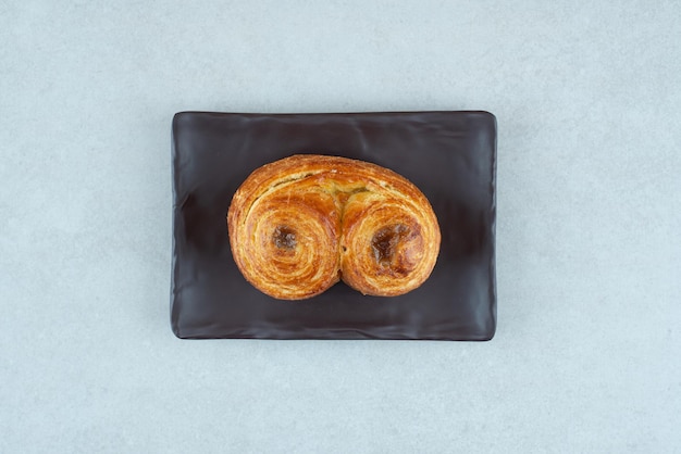 A black plate with sweet delicious pastry on white