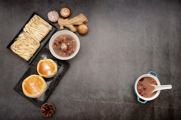 Black plates with noodles and pancakes