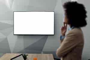 Free photo black projection screen for conference call with african american businesswoman in the office