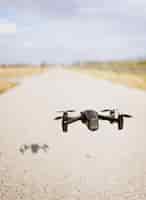 Бесплатное фото Черный дрон quadcopter над облачным небом