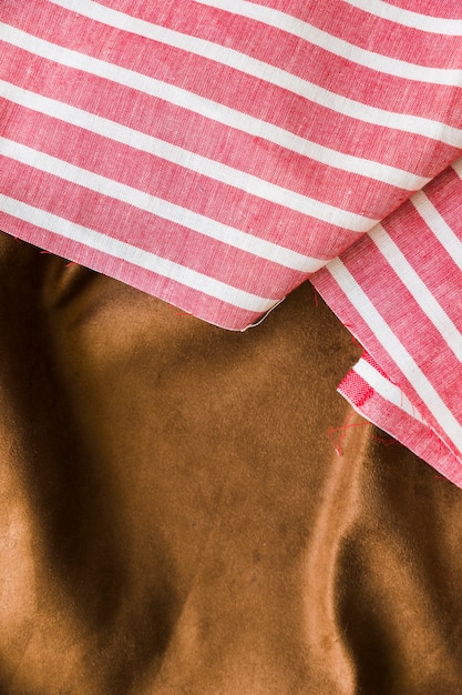 Free photo black and red striped pattern fabric over the smooth brown textile