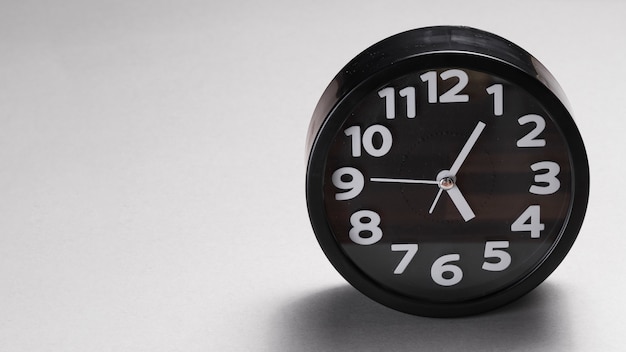Black round alarm clock on gray background