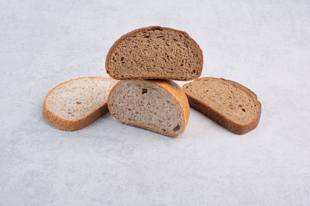 Black and rye bread slices on stone surface