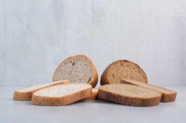 Black and rye bread slices on stone surface