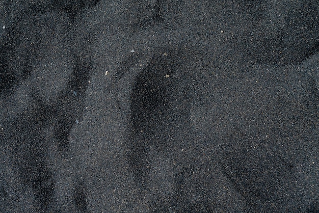Черный песчаный пляж с галькой. Тенерифе вулканический песчаный берег.