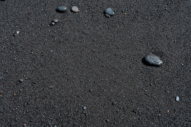 Black sand beach with pebble. Tenerife volcanic sandy shore.