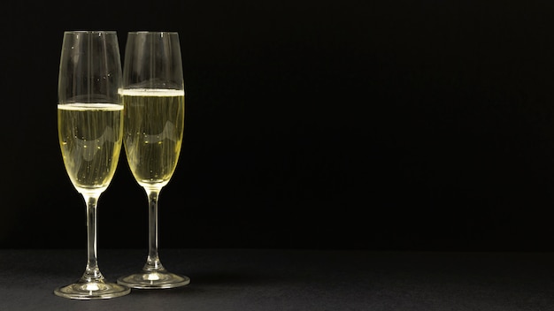 Black scene with two glasses of champagne.