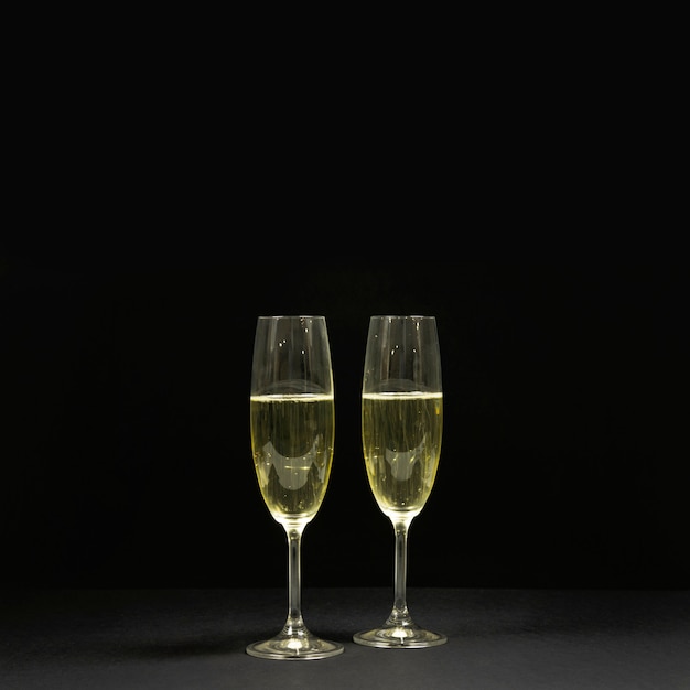 Black scene with two glasses of champagne.