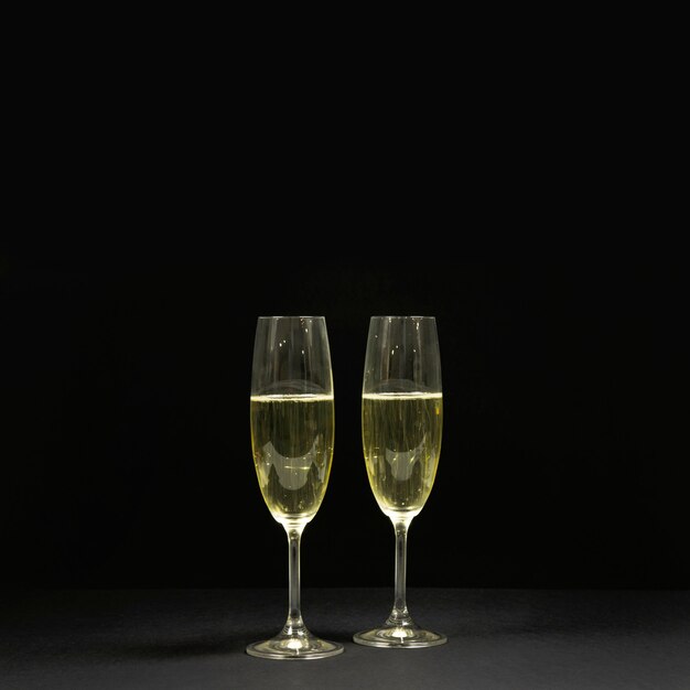 Черная сцена с двумя бокалами шампанского.