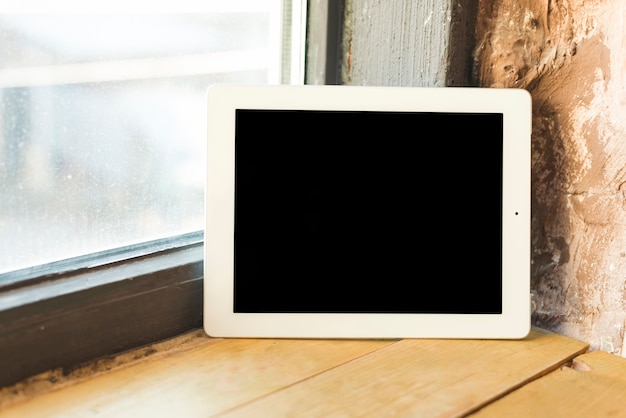 Black screen with digital tablet on window sill