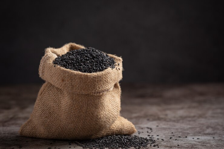 Free Photo black sesame in the sack on dark background