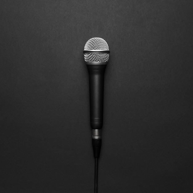 Черный и серебристый микрофон на черном фоне
