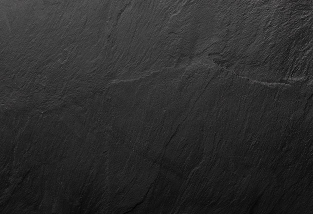 Black slate texture in which the grain of the mineral can be seen. empty table for cheeses and other snacks. copyspace (copy space).