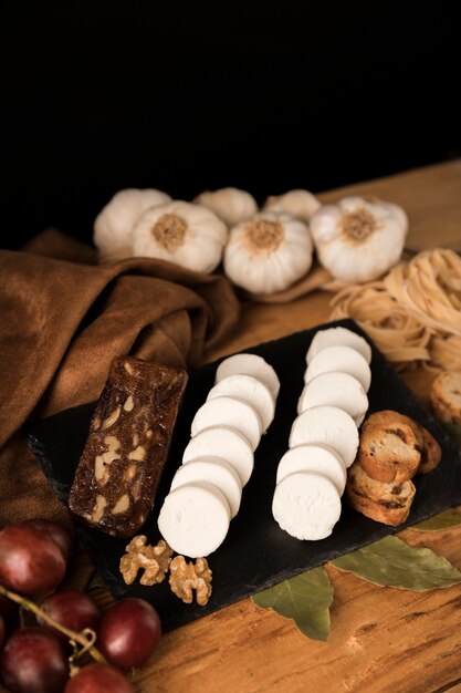 Black slate with different kinds of delicious cheese on table