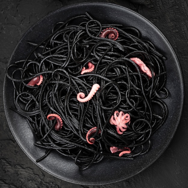 Черные спагетти на тарелке с кальмарами