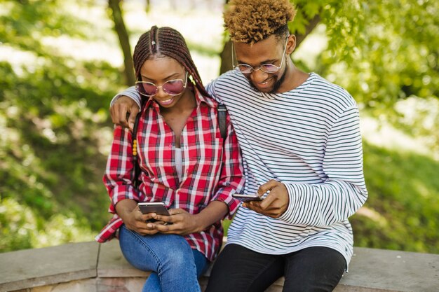 Black students with phones in park