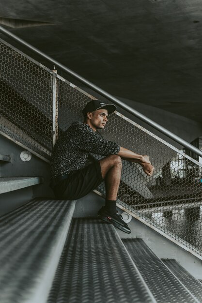 Black stylish guy sitting on the stands