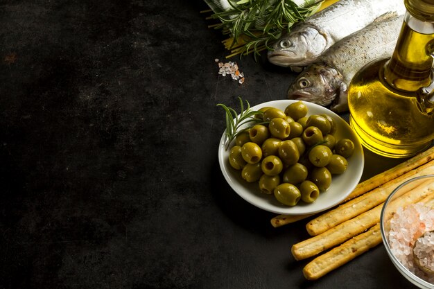 Черная поверхность с вкусными маслинами и другими ингредиентами
